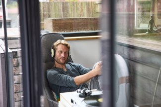 man lounging in a chair, listening to music with headphones