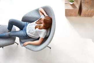 woman is sitting in nive armchair, topshot