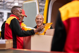 three DHL driver in interaction whikle sorting the shippings