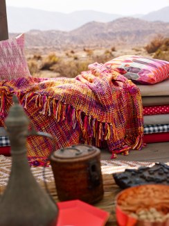 blanket and cushions in a open hut in a desert environment