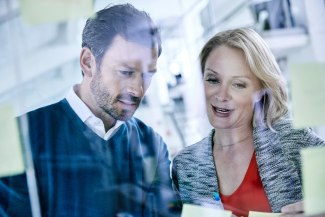 female and male colleagues talking together in office environment