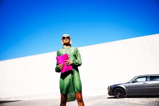 girl with a pink bag in front of a darkblue sky