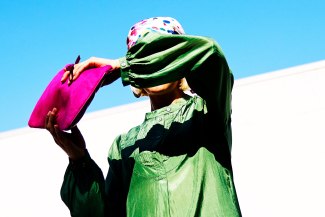 girl with a pink bag in front of a darkblue sky
