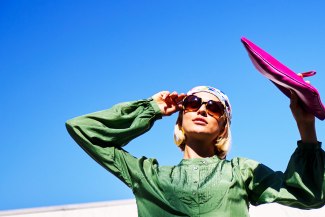 girl with a pink bag in front of a darkblue sky