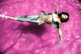 young woman with silver bikini in a pink pool