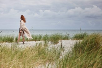 mother standing in the dunes, facing coastline