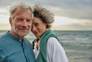 couple on the beach, looking into camera