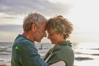 couple standing head to head at the beach