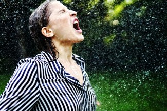 young woman with wet cloths in heavy summer rain