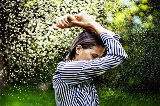 young woman with wet cloths in heavy summer rain