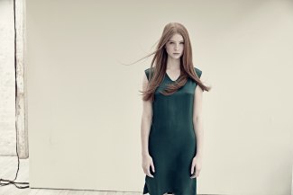 young woman with red hair in green skirt 