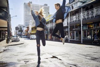 young couple jumping on a street in Capetown
