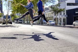 couple jumping over a street