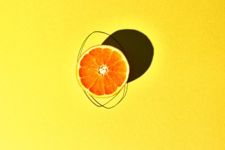 Orangenhälfte auf gelben Hintergrund