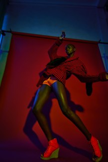 young woman in red cloths dancing in front of red backdrop