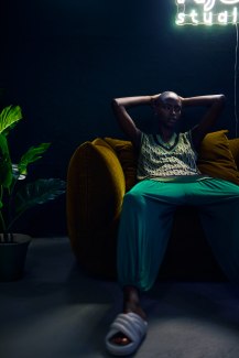young black woman sitting on sofa in dark room