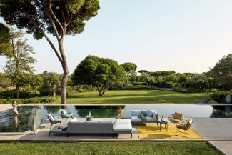 woman swimming in pool with couch on terrace