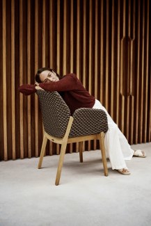woman sitting wrong way on a brown diningchair