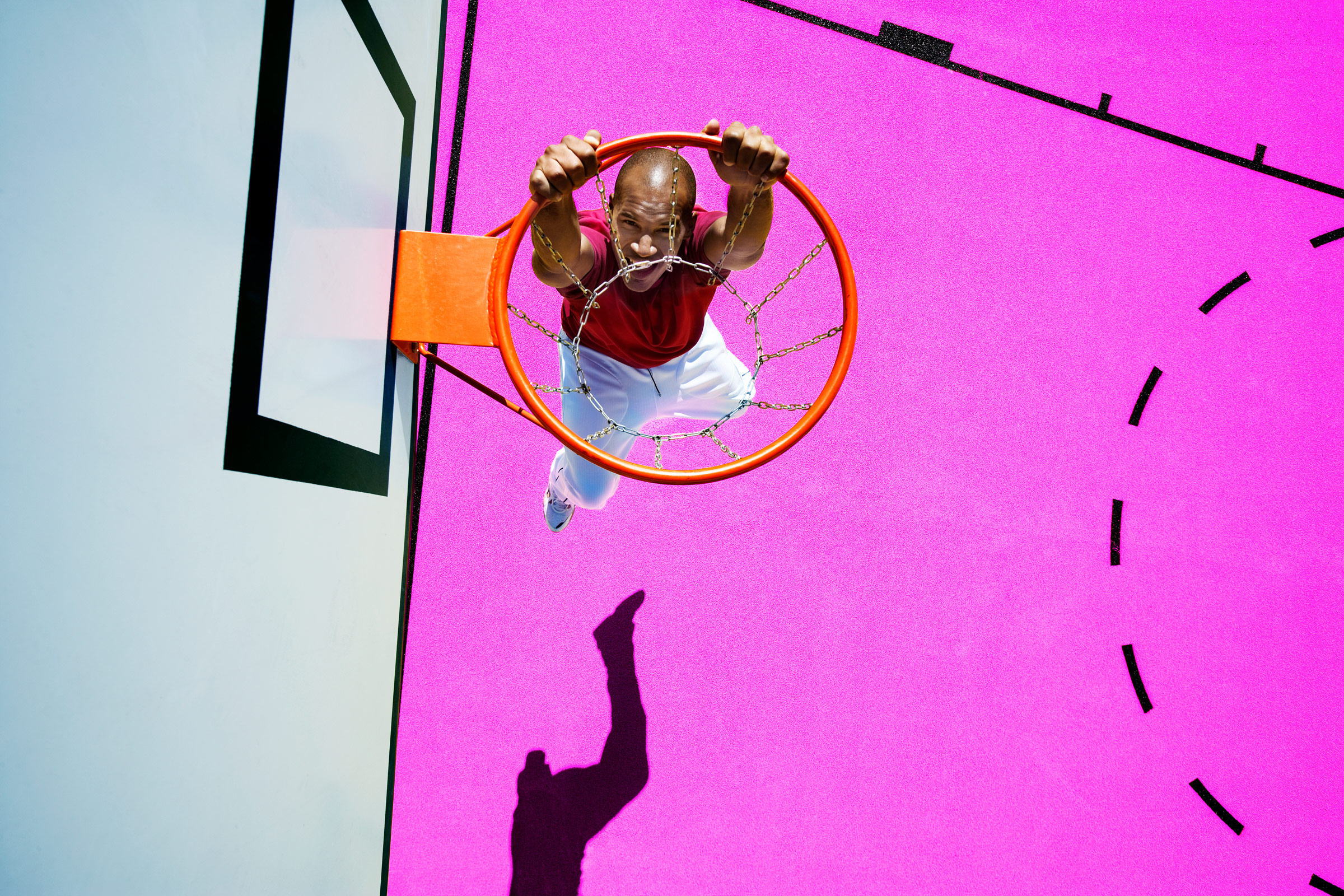 young man playing basketball on pink playground