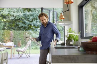 man in the kitchen, grabbing a glass of water