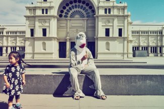 a man in sharkcostume is eating some icecream