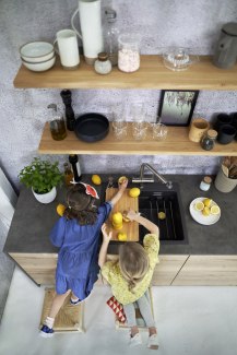 two young girls cutting lemons in the kitchen