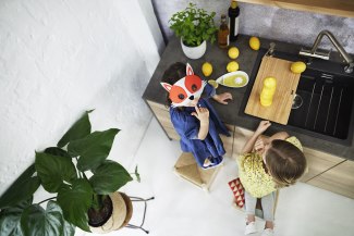 two young girls cutting lemons in the kitchen