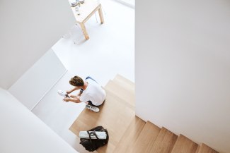 man is sits on stairs putting on his shoes