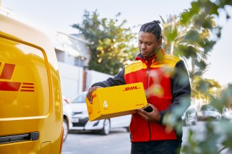 DHL driver looks for the right address on one parcel