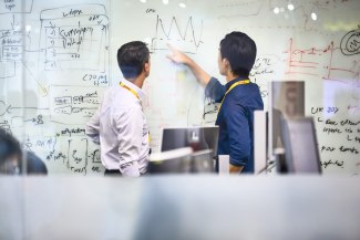 two men in office on a memoboard