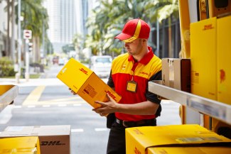 DHL employer sorting parcels in van