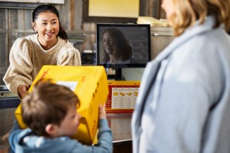 DHL parcel piucked up in a DHL service point by a mother an her child