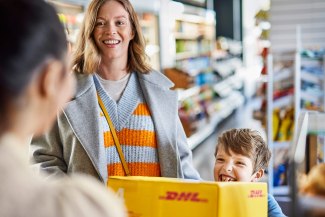 DHL parcel piucked up in a DHL service point by a mother an her child