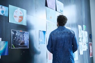 man looking at magnetic pinboard