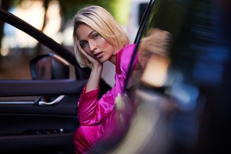 girl with a pink suit sitting in her car