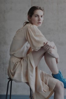 girl in a pale skirt sitting on a stool