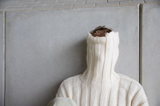 young man covering his face with a turtleneck