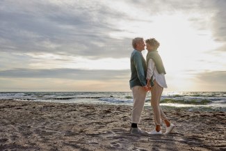 couple standing on the beach, holding hands