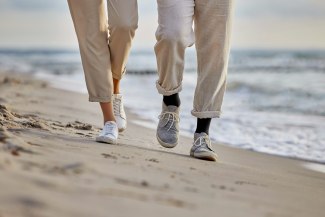 couple walking on the beach, closeup on feet