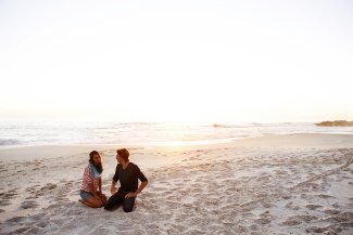 couple sitting together on the beach in sunset