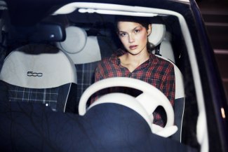 girl sitting in a car, behind the steering wheel