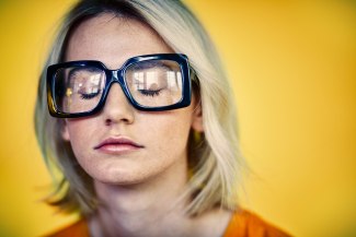 young woman with black glases and closed eyes