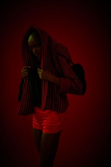 young woman covering her head with her red jacket