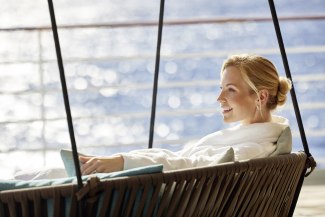 woman sitting in big swing on the spa deck of a cruiseship