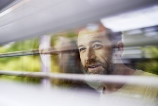 man looking through window blinds man looking through window blinds