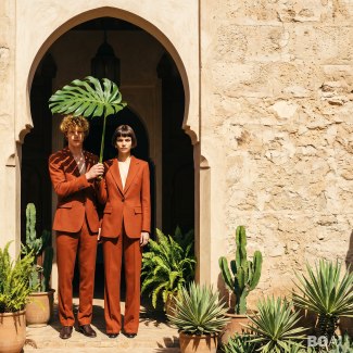 a couple standing together with darkred suits