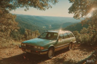 an old 70ies car with some mountains in the background